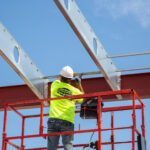 Builder installing anchor bars to super floor joists