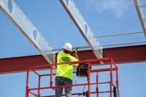 Builder installing anchor bars to super floor joists