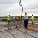 Installers pouring and screeding concrete on Super Floor system