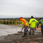 Workers screeding concrete